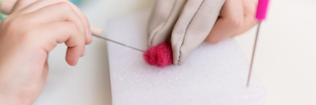 Ręka trzyma igłę nad tkaniną